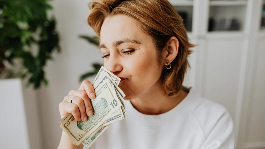 mulher beija notas de dólares