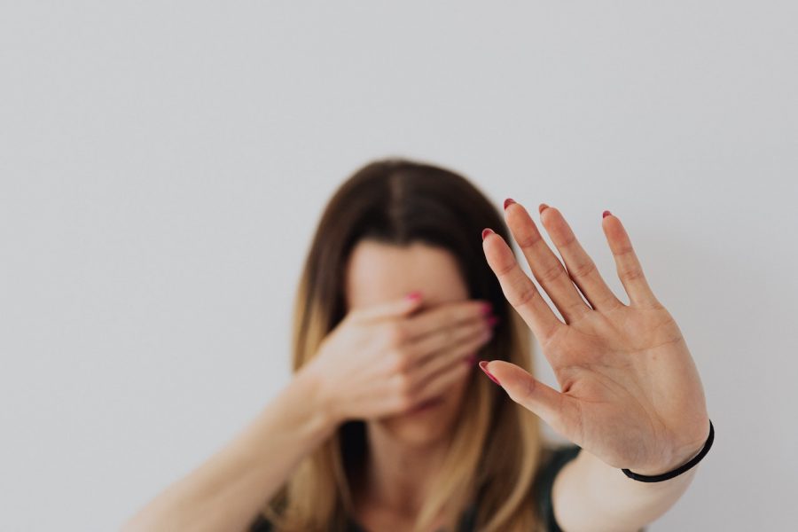 Imagem ilustando mulher tapando os olhos com uma mão e com a outra fazendo sinal de pare